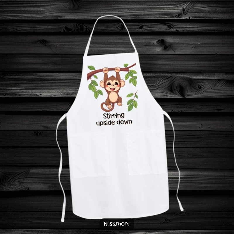 Funny smiling kawaii monkey hanging upside down from a branch, on a kitchen apron, adding a playful touch to cooking.