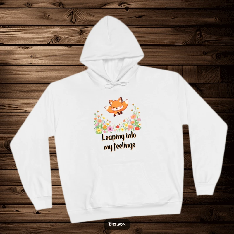 Funny hoodie with a gleeful fox leaping through a field of blooming wildflowers, offering cozy comfort and a cheerful vibe.